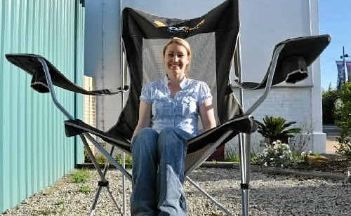 Mango Camping’s Elizabeth Hartshorn, sitting in a larger-than-life chair, says interest has been strong for camping gear.